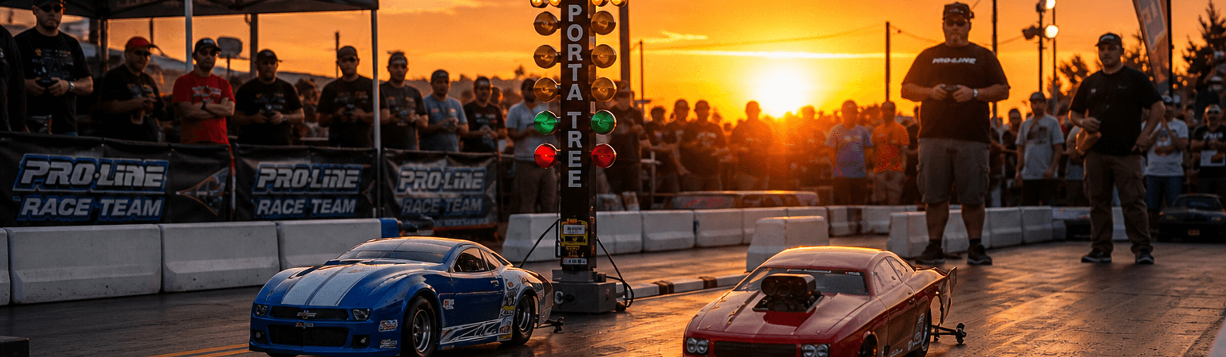 Large-scale RC drag cars at the starting line with spectators and families watching